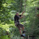 adulte descendant une échelle de corde d'accrobranche