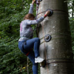 jeune femme grimpant à l'escalad'arbre