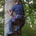jeune homme grimpant à l'escalad'arbre