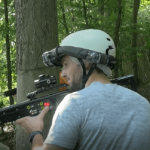jeune homme jouant au laser game extérieur