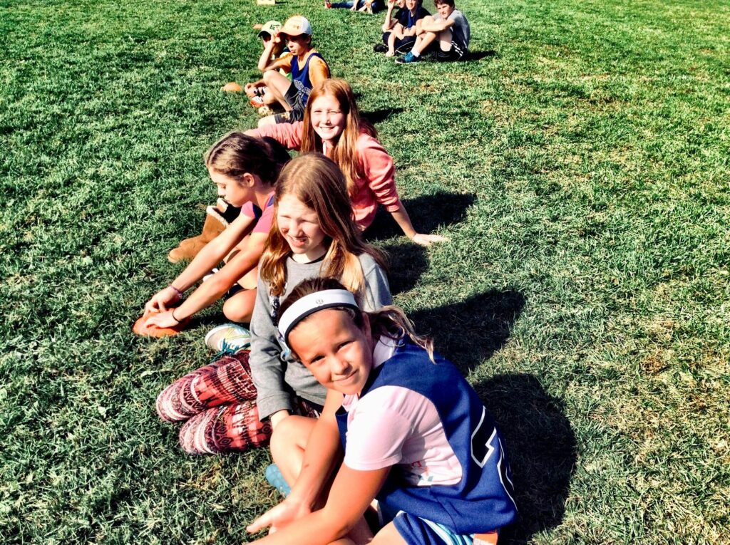 groupe d'enfant assis dans l'herbe pour un anniversaire